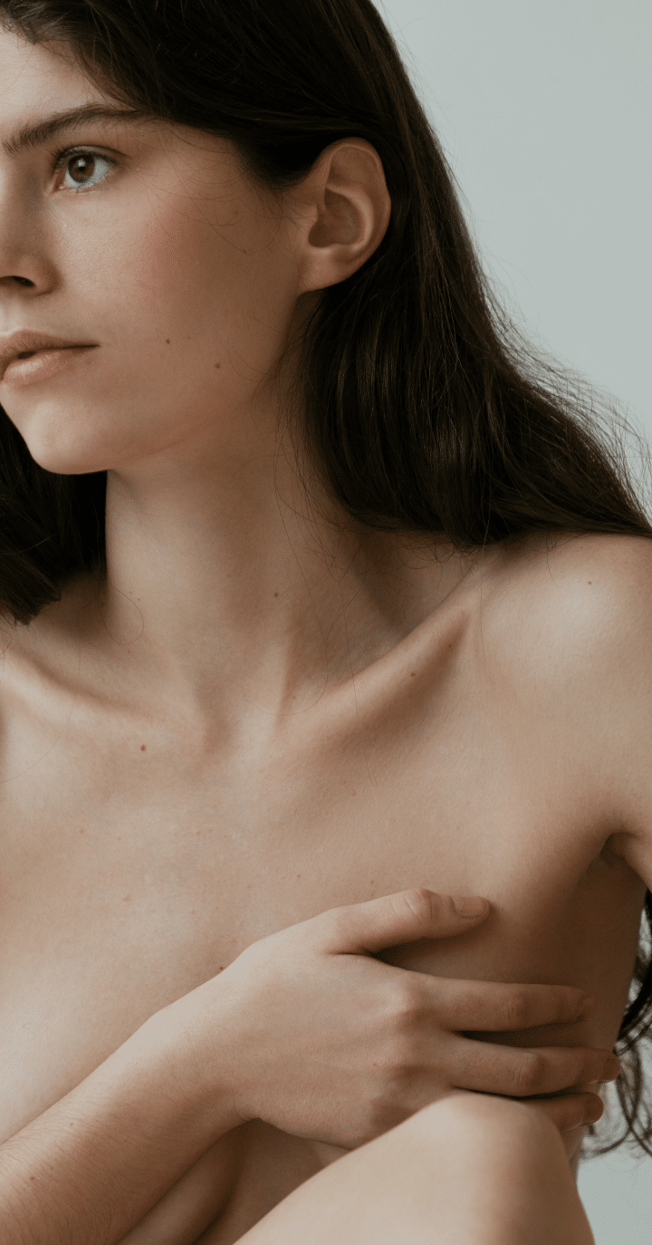 Femme tenant son sein augmentation mammaire.. chirurgie esthetique | Dr Aimard Lyon