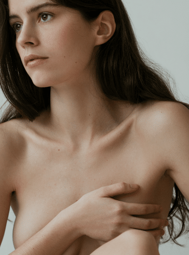 Jeune femme tenant son sein augmentation mammaire. Chirurgie esthetique | Dr Aimard Lyon