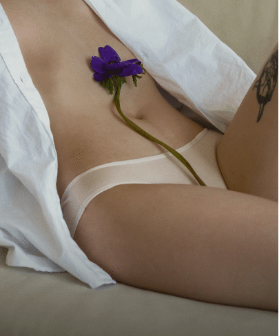 Partie inferieure du corps de la femme avec une fleure sur le ventre. Nymphoplastie |Dr Aimard Lyon