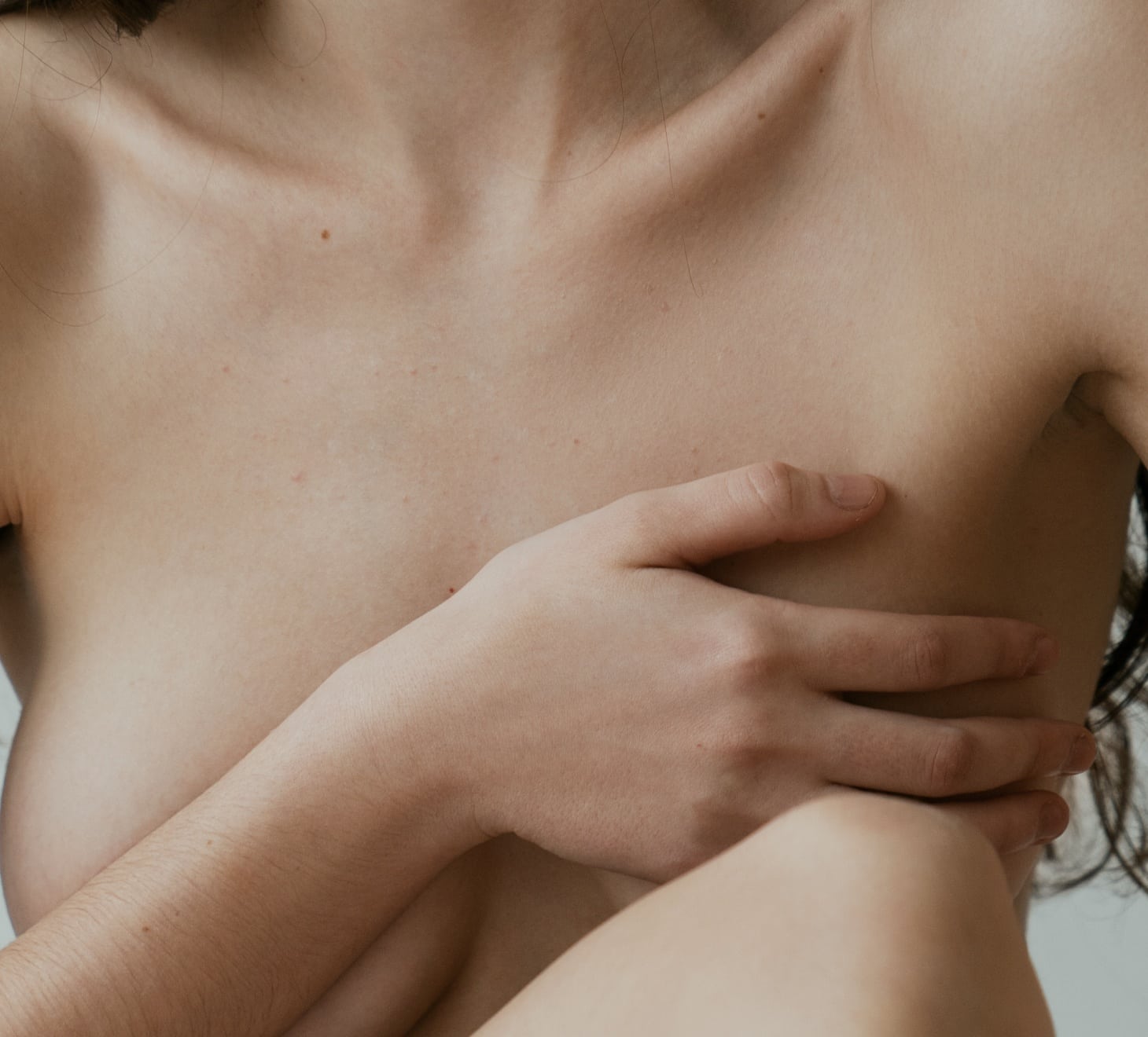 Augmentation mammaire, femme main sur la poitrine | Docteur Romain Aimard